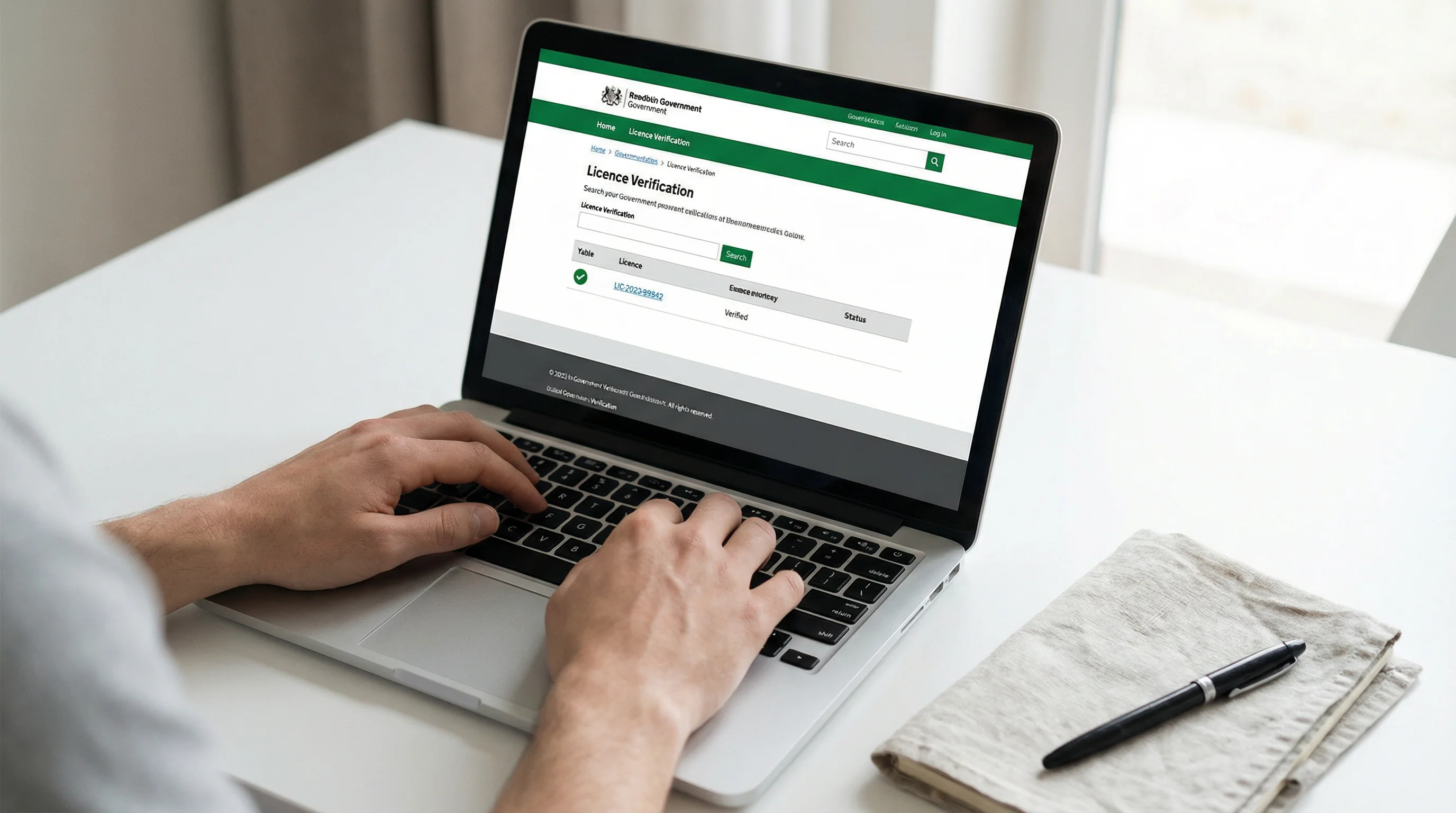 Close-up of hands using a laptop to check a gambling licence verification page on an official regulatory authority website